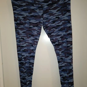 Blå leggings i kamouflagemönster  - Blå kamouflage-mönstrade leggings. Materialet är polyester men känns mjukt. Det står XL, men jag tippar mer på L. Aldrig använda.