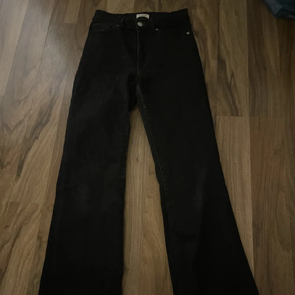 Högmidjade svarta bootcut jeans. Jeans & Byxor.