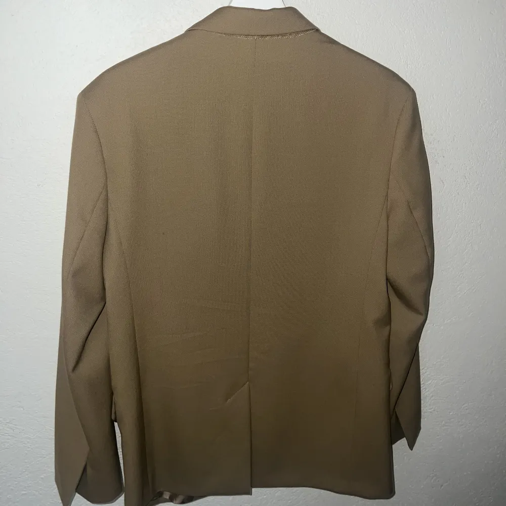 Beige/camelfärgad blazer ifrån Arket, använd 1 gång så i nyskick. Kostymer.