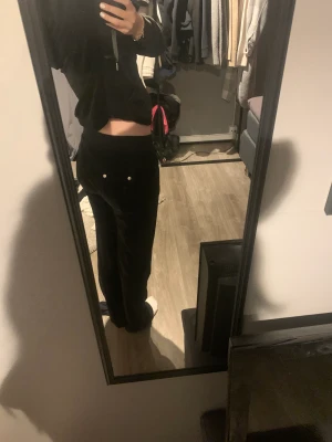 Juicy couture byxor - Svarta juicy byxor storlek S köpte dom från en kompis för 400kr Säljer dom för 1kr dom har tappat en metall grej som sitter på snörena och dom är lite slitna längst ner se sista bilden, men annars jätte fina. Skriv om ni har några frågor😊