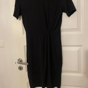 Svart klänning  - Dålig bild! Men tror att man kan se siluetten klänningen har. En liten form av knytning vid midjan