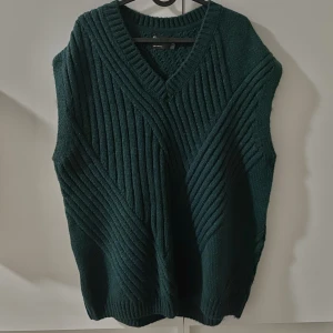Grön ribbstickad väst - En grön ribbstickad väst i storlek L. Aldrig använd och är därmed i nyskick.  