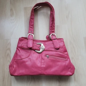 rosa y2k väska - Supersnygg rosa handväska, säljer då det inte är min stil. Är i gott skick men bara lite sliten i kanterna som man ser på sista bilden. Pris är diskuterbart vid snabb affär!