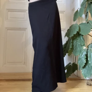 Svart maxikjol  - Tidlös svart maxikjol i viskos. Stl M men sitter lågmidjat på mig som är S. Jag är 165cm för referens.  Köpt second hand men i mycket bra skick. Priset kan diskuteras. Köparen står för frakten men kan även mötas upp på Södermalm i Stockholm. 