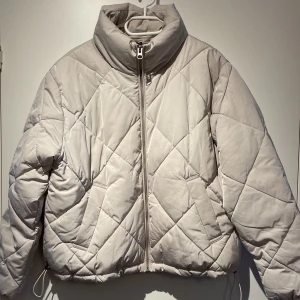 Vitgrå quiltad jacka - Superfin och go jacka från H&M, Divided. Jackan är i väldigt fint skick! 🤍 den har fickor och kan dras åt i nederkant, se bild 🥰