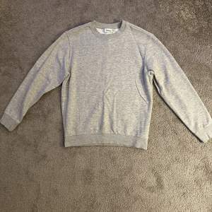 En ljusgrå Weekday Sweatshirt i storleken S. Den är i väldigt bra skick 9/10 endast använd ett fåtal gånger. Nypris 360 kr!