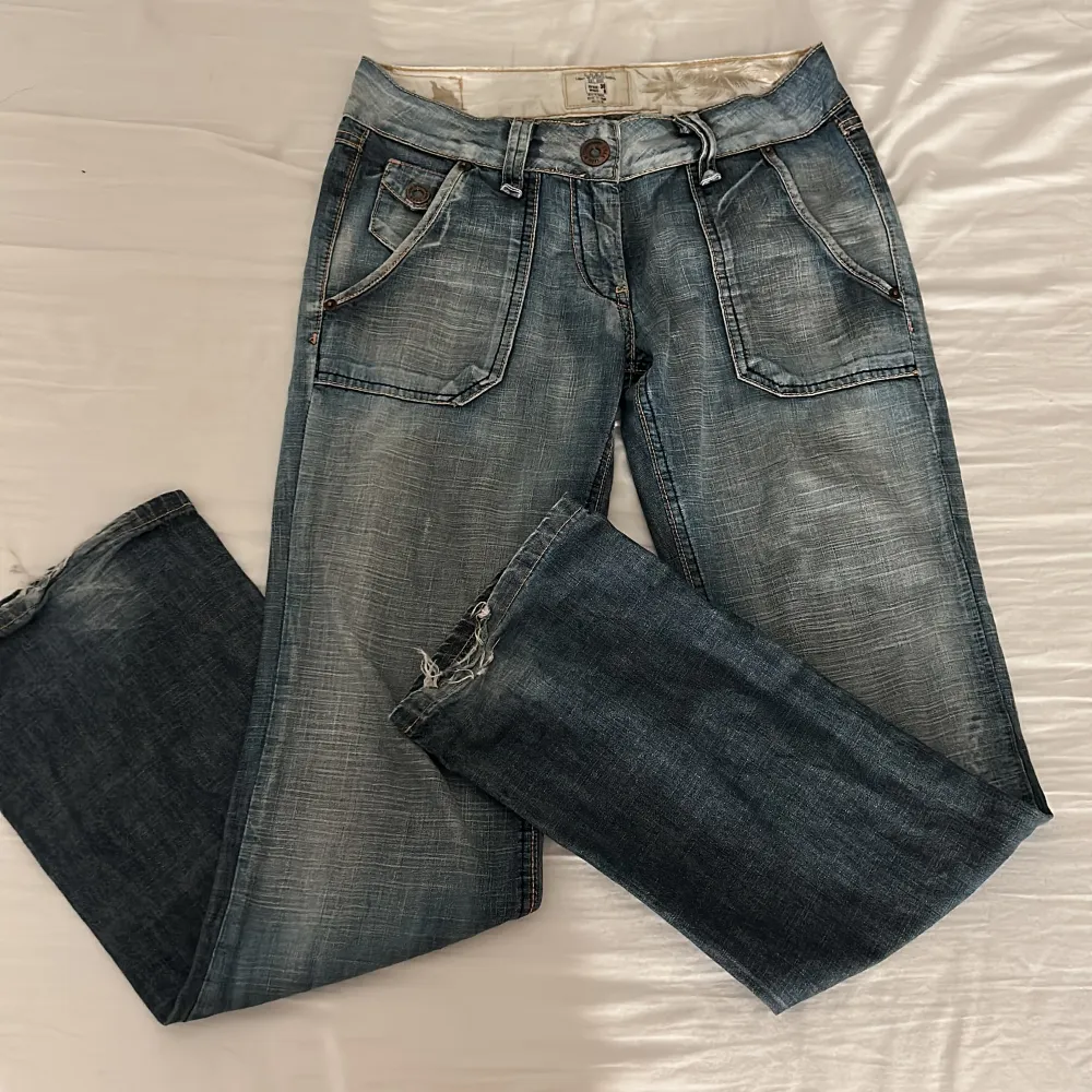Säljer ett par vintage jeans som är bootcut och low waisted . Jätte fina och bra skick utom slitningarna ner till som syns på bilden💗säljer då det tyvärr är lite små för mig💗. Jeans & Byxor.