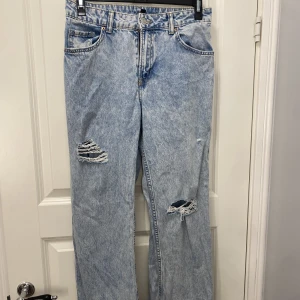 Jeans H&M - Jeans från H&M, hål på båda benen, lågmidjade. Det är storlek 36 Jag är 170cm och bär oftast 36 i mina jeans men dessa var förkorta i benen. Original pris: 300kr