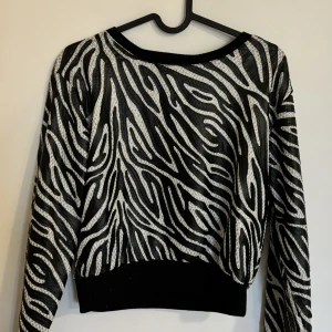 Tröja  - Svart vit tröja med glittrande detaljer. Som ny 