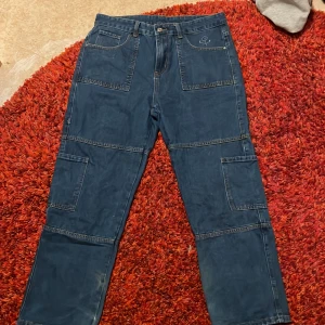 Blå baggy jeans  - Ett par blå jeans jag köpt secondhand förra vintern så vet inte riktigt vart dom är ifrån. Inga större defekter lite trasiga längst ner men inte mycket alls. 