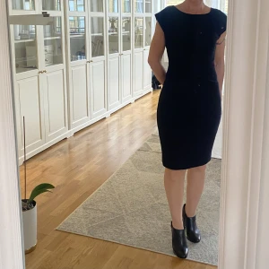 Svart klänning  - Säljer denna eleganta klänning från tiger of Sweden. Den är knälång på mig (162cm). Enkel svart klänning som framstår som mycket elegant.