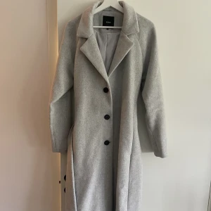 Kappa - Lång, grå, tjock kappa från object. Lite värmare, går ned till vaderna. Fint skick, knappt använd. 