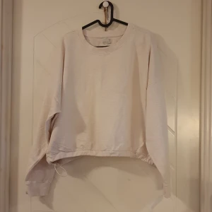 Tröja - Beige-vit tröja med dragsko i midjan, vilket gör att man kan dra in tröjan i midjan. Etirel. Köpt på Intersport. Storlek XL. 