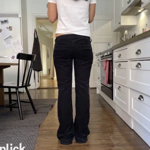 Lågmidjade byxor - Svarta lågmidjade byxor i manchester. Midjemått 38 cm rakt över. Innerbenslängd 79 cm. Modellen är 169 cm