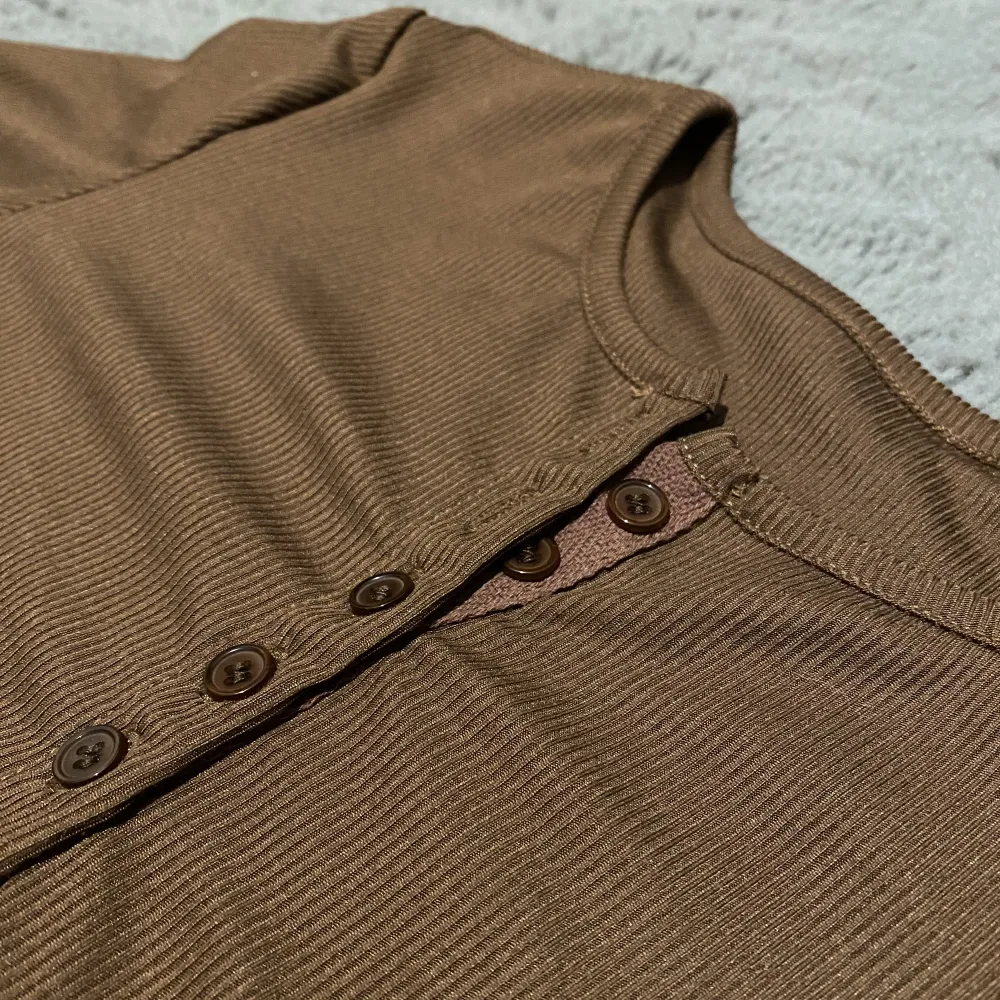 Jättefin brun tröja med knappar i storlek S! Endast testad. Färgen i verkligheten är mest lik bild nummer 2 förutom att det ser rosa ut vid knapparna, vilket det inte gör. Priset går absolut att diskuteras🫶🏻. Tröjor & Koftor.