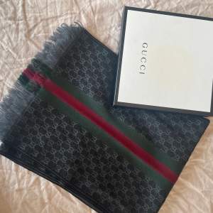 Gucci halsduk i nyskick.  Material; Ull Mått: 37x180cm  Originalbox medföljer 