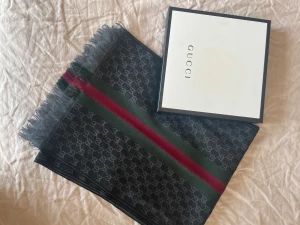 Gucci halsduk i nyskick - Gucci halsduk i nyskick.  Material; Ull Mått: 37x180cm  Originalbox medföljer 