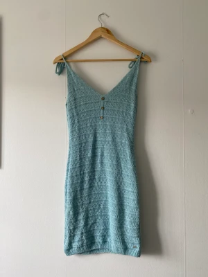 Klänning - Stickad klänning. Liten i storlek med justerbara band. Köparen står för frakten. 