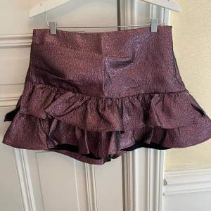 Rosa/lila glittrig metallic kjol från zara. Mini volangkjol med shorts under. Endast använd ca 4 gånger!