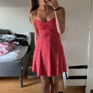 Klänning  - Jätte söt röd och blommig klänning i storlek xs. Har knytning i ryggen och har justerbara axelband. Säljer på grund av att den inte kommer till användning. Skriv om du vill ha fler bilder 💕💕
