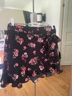 Blommig kjol - Så fin kjol med volanger och knytdetalj, passar perfekt till vardags men också festligare tillfällen💗