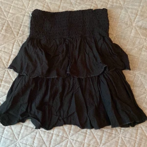 Svart kjol -  Tajt där uppe men lös där nere, svart