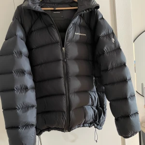 Peak performance dunjacka - Nypris 3300 för 2 vintrar sedan. Sparsamt använd och säljs då den bara hängt i garderoben sedan två säsonger. Lite liten i storlek så skulle sagt den passar stor L/XL bäst.   Kom med ett bra bud om priset inte passar så löser vi en bra och snabb affär! 