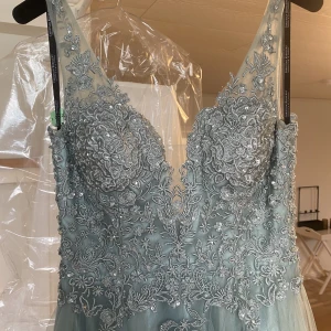 Balklänning stl 36 - Säljer min jättefina balklänning som jag använde på balen 2022. Passar mig som är 167 lång + låga klackar. Den är mintgrön i färgen. I priset ingår också handskar och underkjol (den största modellen). Den är kemtvättad, men en liten fläck gick inte bort