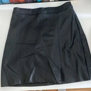 Skinnkjol  - Säljer denna skinnkjol med slit! Väldigt bra skick! 