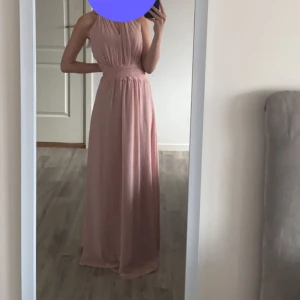 Balklänning  - Jättefin rosa balklänning från VILA i storlek 34. Helt oanvänd och prislappkvar. Inga fläckar eller skador. Dragkedja på baksidan. 