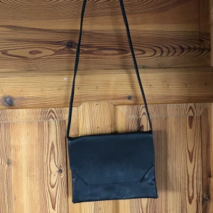 Svart axelväska  - Svart axelväska, aldrig använd.  Frakten ingår i priset💚