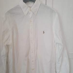 Säljer sonens vita Polo Ralph Lauren skjorta i strl L. Slim fit. Sparsam använd. Mest hängt i skåpet.  Hämtas i Göteborg eller Kungölv. Kan skickas om köparen betalar frakten.