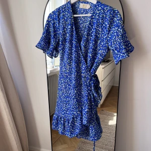 Blå sommarklänning - Omlottklänning från märket Chelsea. Multifärgad/blå. 