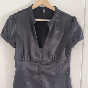 Topp - Svart topp i satin/silke tyg. Framkommer inte så tydligt på bilder men är mjuk satin💓. Topp med knappar. Mycket mycket bra skick.🕯️