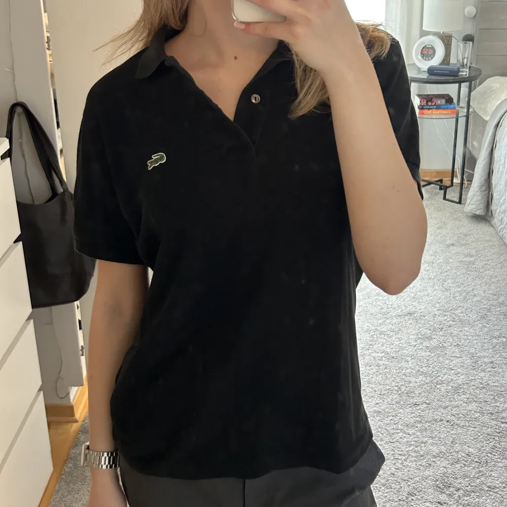 Thriftad svart Lacoste tröja i storlek 3 UK (ungefär 36 EU). Använd fåtal gånger av mig men är i väldigt fint skick!. T-shirts.