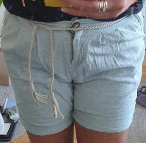 Ljusblå linneshorts  - Ljus/babyblå 100%linne shorts säljs i mycket gott skick. Två fickor bak och på sidorna samt ett flätat skärp i midjan. Strl 38/40 Pris 100kr 