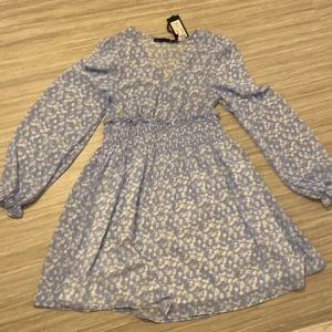 V ringad klänning från lager 157 - Jag säljer den här jätte fina blåa klänningen med vita blommor på från lager157. Den har aldrig blivit använd och är storlek XS