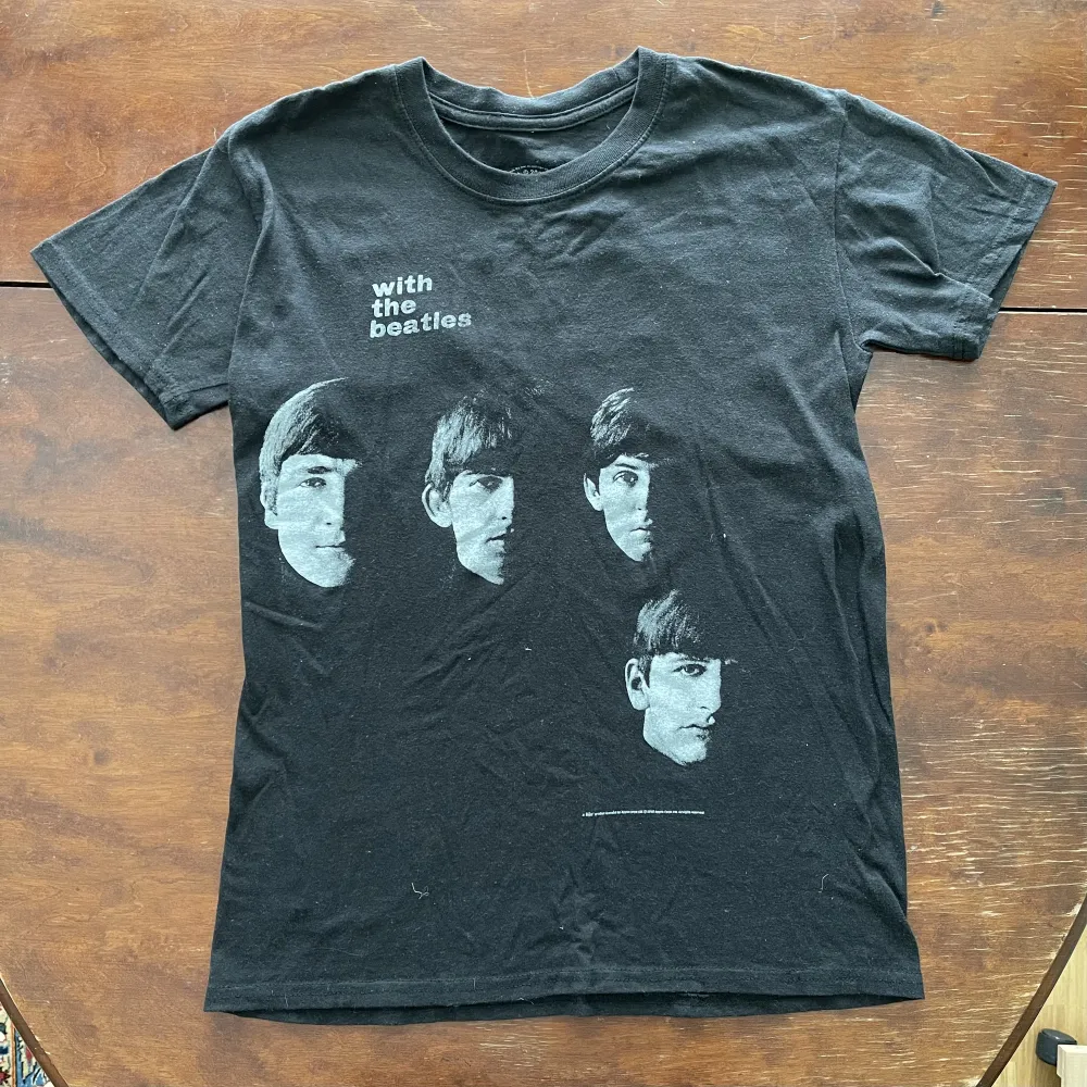 Köpt på The Beatles Museum i Liverpool. Knappt använd och i mycket fint skick. Ser grå ut på bilden men är svart. Passar unisex som S. Bredd: 42 cm. Längd: 60. T-shirts.