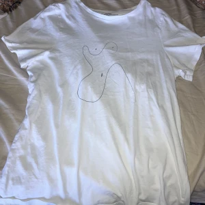 Vit tröja med tryck  - Tröjan har ett tryck av en neck kvinno kropp på. Skönt och tunt material. Tröjan sitter snäppet för tight och därför säljer jag den. Tröjan är lite see-through men det märks inte om man har vit topp/BH under.