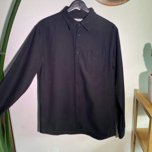 En HOMEBOUND Skjorta i kraftigt bomull med framficka.  (Mörkare än den framstår på bilden) Regular medium, sann i storleken. Längd 75cm