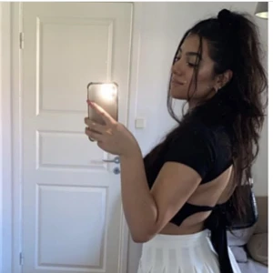 Croppad topp PLT - Säljer en croppad topp från Prettylittlething med öppen rygg. Den har två band man kan knyta med. Endast använd en gång och inga defekter. Storlek 40 men väldigt liten i storleken, passar 36-40. 