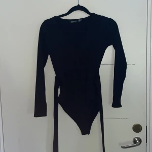 Svart body - Body från Boohoo som man kan knyta i midjan.