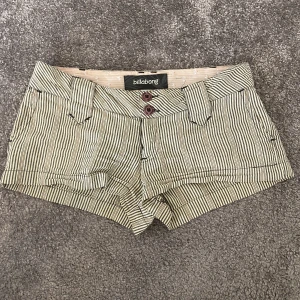 Lågmidjade shorts - Perfekta sommarshortsen. Randiga, lågmidjade korta shorts med knappar på fickorna. Fina sömmar och från märket Billabong som inte längre säljer designen.