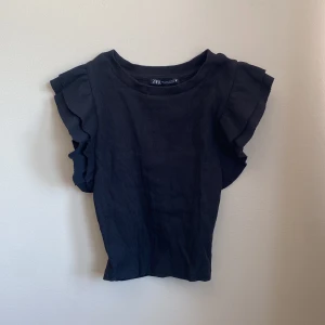 Topp från zara - Svart topp från zara med lite volang på ärmarna.