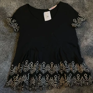 Volang topp - Säljer en superfin svart volang topp med broderi längst ner och på ärmarna. Den är i superbra skick och har även prislappen kvar. Säljer då den tyvärr var för stor. Skriv om ni har frågor eller för fler bilder💗🥰