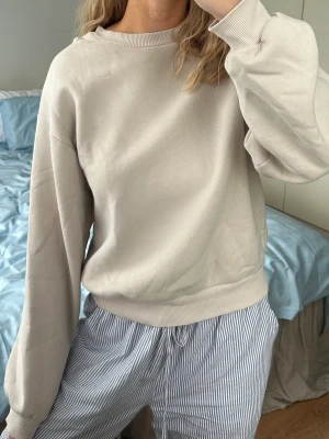 Beige sweatshirt  - Beige sweatshirt från Gina Tricot. Använd men i bra skick. Tyget har dock formats efter att den varit upphängd på ett ställe. Se sista bilden 