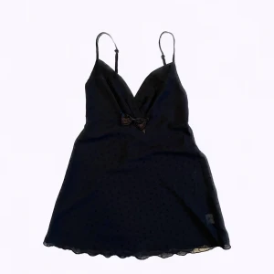 Så fin coquette svart top nattlinne S - Very cute black top (slipdress style) from Hunkemöller size S. The part on the chest in NOT see through, but the other part is see through. Cute floral details (see 3rd picture). There is a little bow detail but it can be easily removed. Never worn