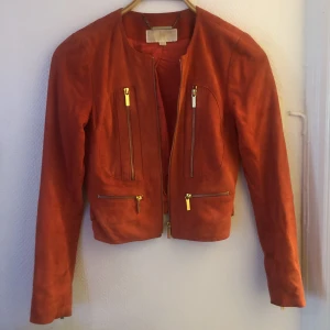 Michael kors jacka  - Äkta Michael Kors jacka i mocka. Skulle säga att färgen är mer ljusröd än på bilden.