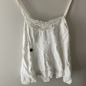 Vit volangtopp  - Superfin volangtopp perfekt till sommaren, säljs pga för liten så kan tyvärr inte ta bild på hur den sitter på. Ca storlek xxs, frakt tillkommer🤍