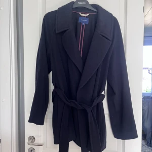Marinblå kappa från GANT - Säljer denna fina marinblåa kappan, i bra skick och pris! Storlek Xl men passar S och M.
